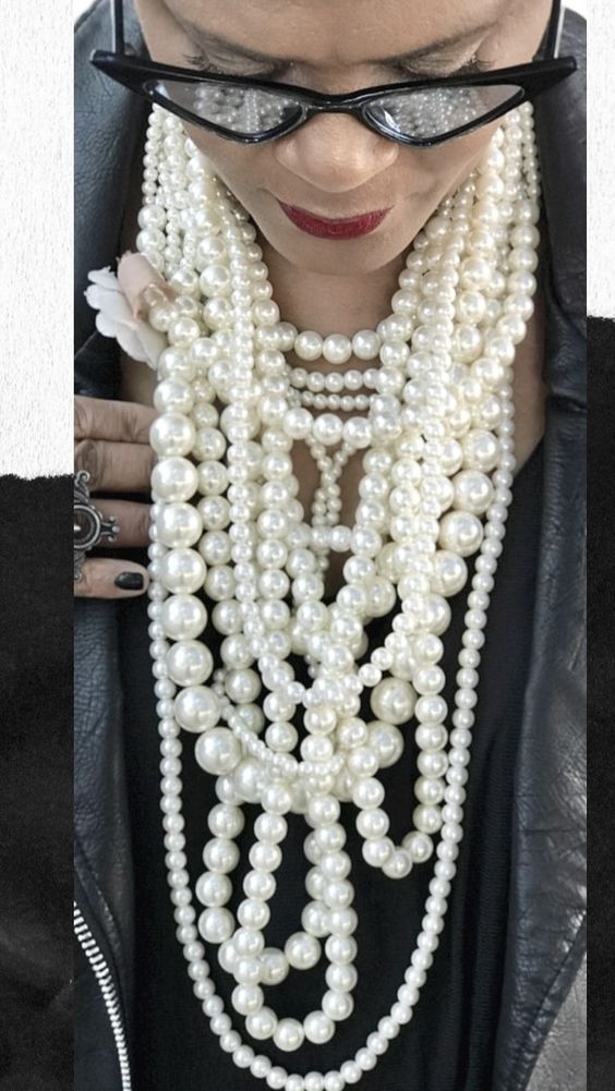 Model wearing white oversized beaded necklaces. 