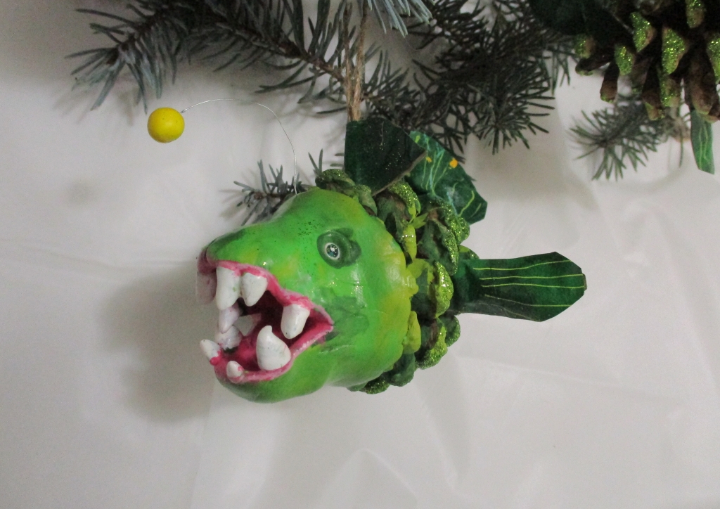 Green Anglerfish Holiday Ornament made from Pinecones and clay by Marelle Couture. https://hopscotchcouture.com/ #AnglerfishOrnament #Pineconeornamets #Greenfishornament 